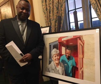 Care home manager Gez Ossai with his portrait and resident Gloria. Credit: Angeline Albert