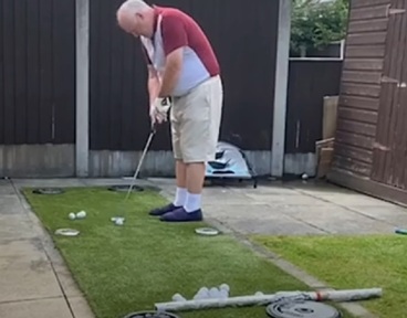 Tommy Dunne tries out his homemade golf driving range in his back garden in Liverpool.