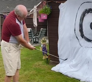 Tommy Dunne keeps active by practicing his golf swing in garden.