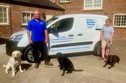 Tim Jackson and Dog Trainer Cath Jarred with the Animal Assisted Therapy van and dogs JJ, Asha and Acer. Credit: Caremark