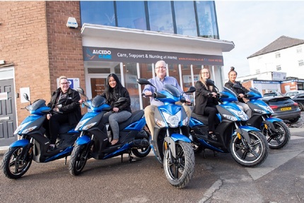 Andy Boardman (centre) along with the Alcedo team on their mopeds. Credit: Alcedo Care.